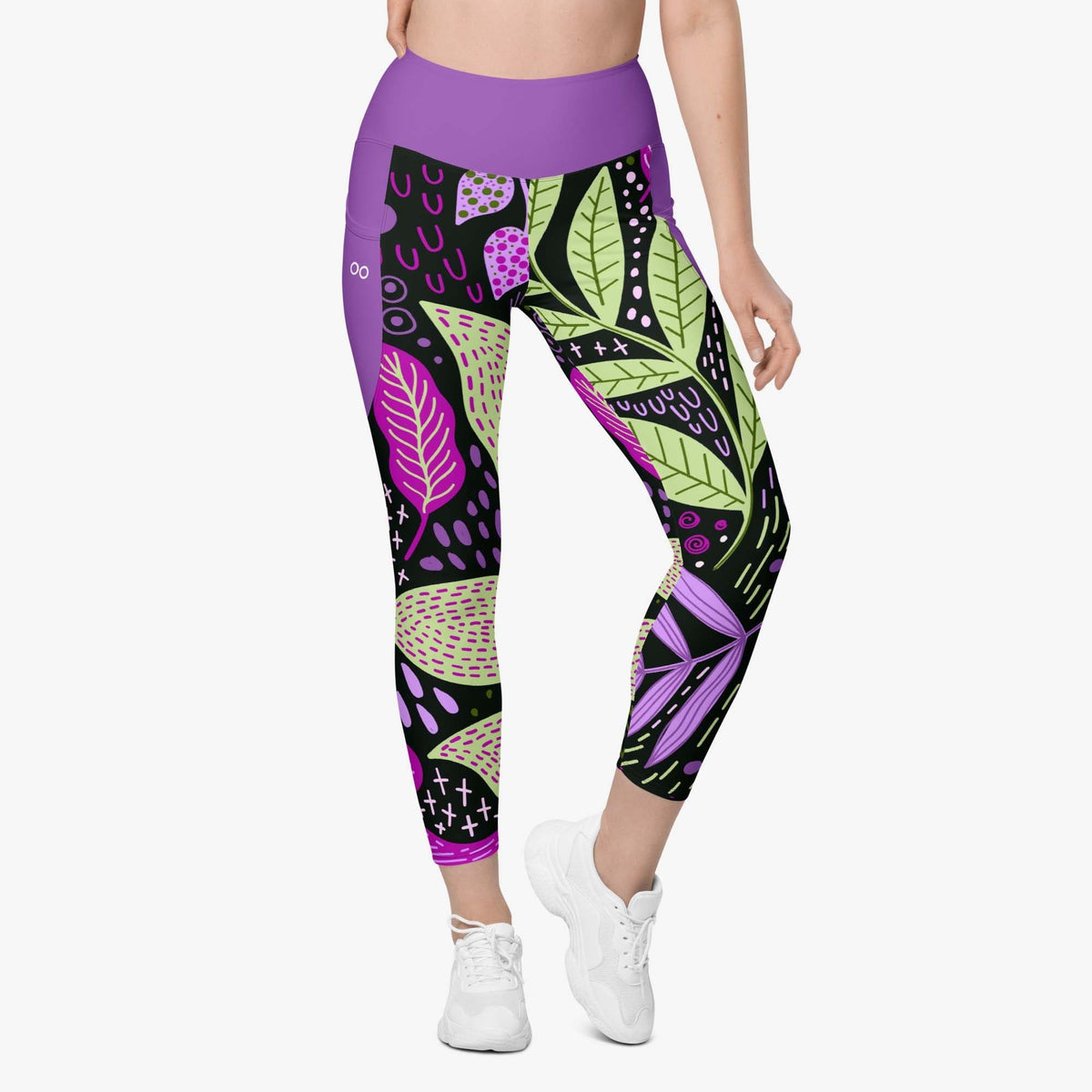 Front view of white leggings with pockets and abstract print.